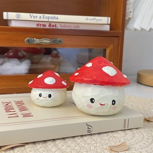 Detailed view of two cute mushroom desk ornaments with smiling faces and carved texture