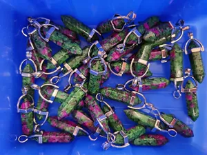 Bulk ruby in zoisite hexagonal crystal pendants stored in a warehouse tray
