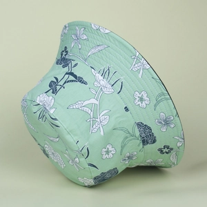 Detailed close-up of hand-painted floral pattern on a mint green cotton bucket hat