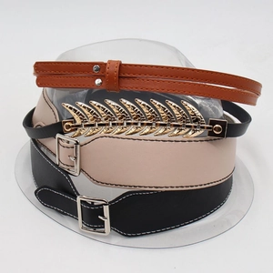 Detail view of retro faux leather hat bands with golden leaf accents and metal buckles