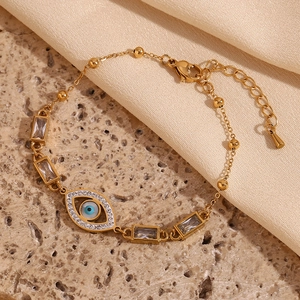 Detailed close-up of 18K gold plated bracelet with evil eye charm and baguette zircon