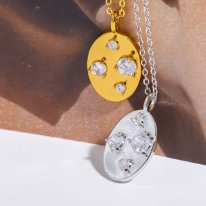 Macro shot of gold and silver irregular oval necklaces featuring four zircon stones