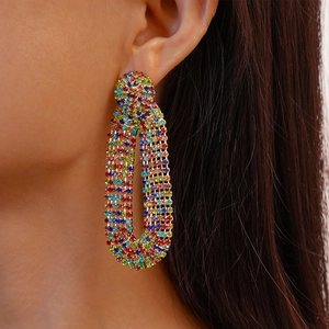 Luxurious gold geometric earrings with colorful zircons worn by a female model