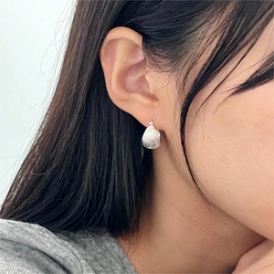 Close-up of minimalist S925 sterling silver brushed hoop earring worn by a model