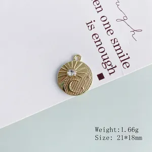 Close-up of golden sun and moon alloy pendant with rhinestone and ring attachment