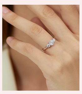 Detailed view of a 1 carat moissanite ring with a classic three-stone setting on a hand