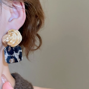 Detail shot of vintage square leopard print pendant earrings worn on model's ear