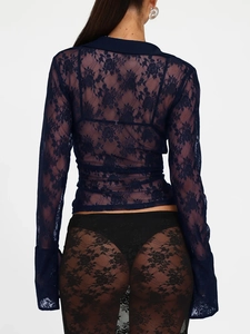 Back view of a long-sleeved dark blue lace top paired with a black lace skirt on a model