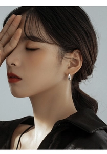 Minimalist silver teardrop hoop earrings shown on a model with a polished finish