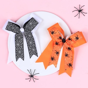 Detail of Halloween hair clips featuring spider web patterns on black and orange ribbons