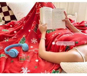 Detail of soft thick red Christmas flannel blanket with white snowflakes and tree patterns