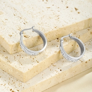 Macro view of silver stainless steel hoop earrings with double row crystals on stone