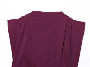 Detailed close-up of shoulder pleats and padded design on wine red top for women