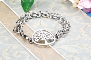 Close-up of a double-layer silver stainless steel bracelet featuring a Tree of Life pendant