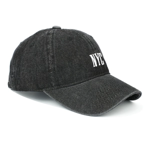 Close-up of white NYC embroidery on retro washed black denim baseball cap with side stitching