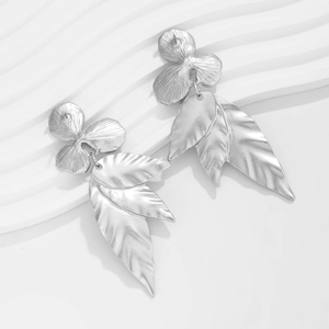 Macro detail of silver ginkgo leaf earrings with fine texture and matte metallic finish