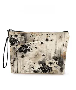 Detailed pattern view of a canvas cosmetic bag with black ink floral print and wrist strap