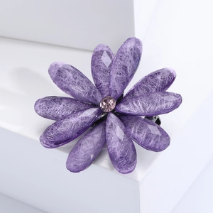 Detail of purple acrylic flower brooch with resin texture and center rhinestone crystal