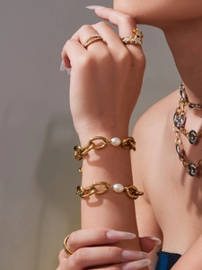 Close-up of 18k gold plated chunky chain bracelet and pearl rings on model