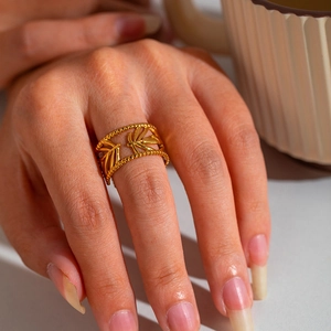 Close-up of golden hollow palm design ring in 18K titanium steel on model's hand