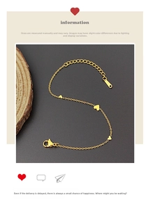 Detail view of gold heart bracelet featuring polished charms and stainless steel lobster clasp
