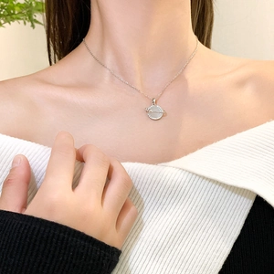 Saturn necklace with cat-eye stone and tiny diamonds on silver-plated chain worn by model