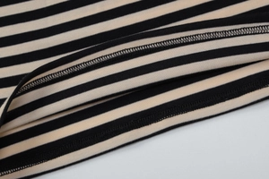 Gros plan détaillé de l'ourlet en tricot rayé avec une finition de couture à double aiguille