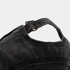 Detail of adjustable metal buckle and washed cotton texture on dark grey cadet hat
