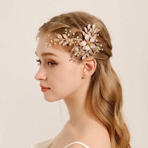 Luxurious gold flower bridal hair clip with pearls and crystals on elegant model