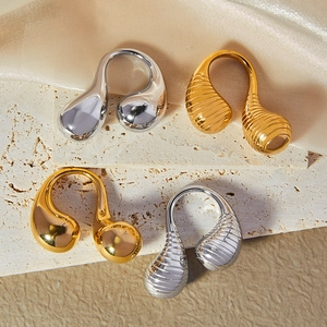 Minimalist double teardrop open ring in gold and silver finishes on marble