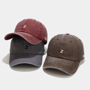 Détail de trois casquettes de baseball vintage délavées avec broderie Z en rouge, gris et marron
