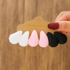 Detailed macro of matte white, pink and black C-shaped acrylic hoop earrings set