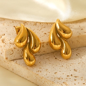 Vue détaillée des boucles d'oreilles goutte en acier doré 18k sur pierre et soie
