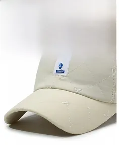 Detail of diamond quilted baseball cap with blue bird embroidery and white logo patch