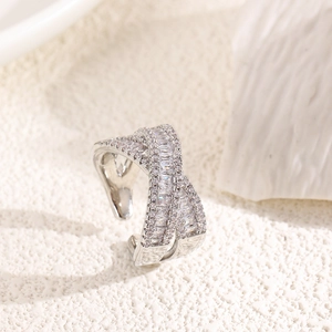 Macro detail showing the silver-plated X-shaped cross ring with baguette-cut cubic zirconia