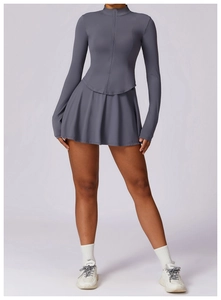 Détail d'un ensemble sport gris foncé avec haut zippé manches longues et jupe plissée