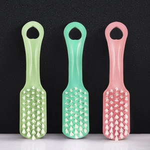 Three small cleaning brushes in green, teal, and pink with white bristles and hanging holes
