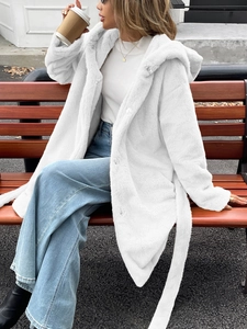 Manteau blanc élégant en peluche à capuche avec ceinture dans un cadre extérieur naturel