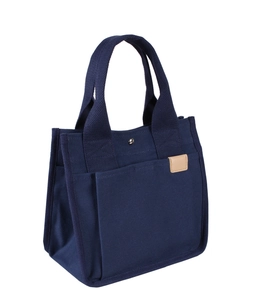 Detail der dunkelblauen Canvas-Tasche mit Lederetikett, Fronttasche und Metalldruckknopf