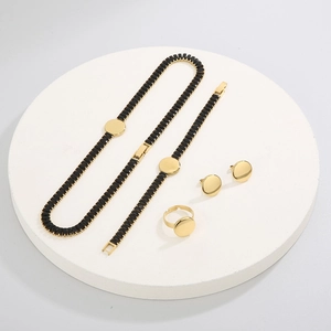 Vista piatta del set di gioielli in oro e acciaio con anello e collana in zircone nero