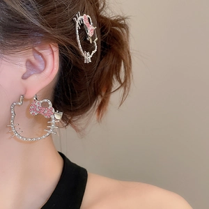 Detail of crystal encrusted kitty earring and matching hair clip set on a model