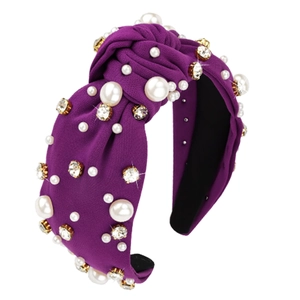 Close-up of purple fabric knotted headband with white pearls and sparkling rhinestones