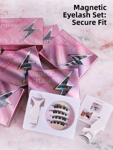 Flat lay of magnetic false eyelashes set with white applicator tool on marble background