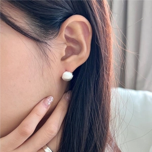 Close-up of a model wearing 925 silver stud earrings with a matte brushed finish