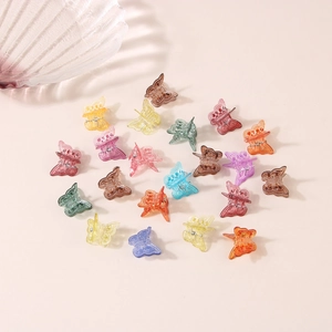 Flat lay of small butterfly hair claws in colorful translucent candy tones and matte finish