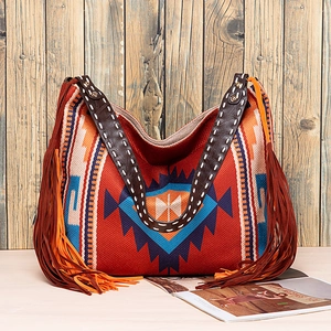 Macro detail of Bohemian woven tote bag with fringe tassels and leather handles