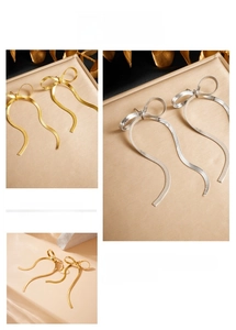 Detail of bow-shaped tassel earrings featuring gold and silver snake chain fringe