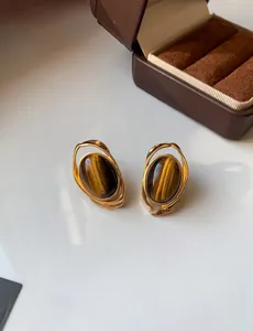 Dettaglio degli orecchini vintage occhio di tigre dorati su un portagioie in velluto
