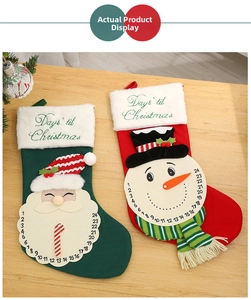 Close-up of knit Christmas stockings with 24-day countdown clock and Santa snowman motifs
