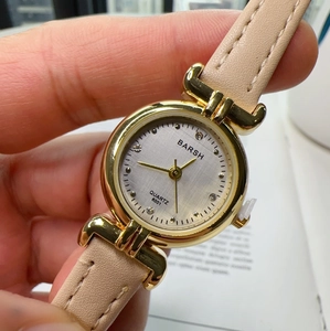 Detail of a ladies quartz watch with beige leather strap and crystal hour markers